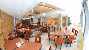 A spacious cafeteria with multiple tables and chairs, a high ceiling with recessed lighting, and a view of the dining area through large windows. - Dalhousie University Accommodations (Halifax)