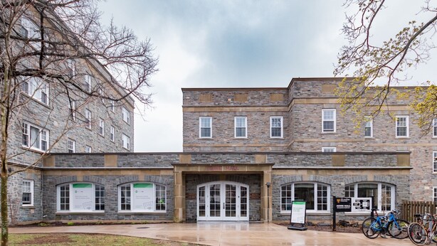A stone building with multiple windows and a central entrance. There are bicycles parked outside. - Dalhousie University Accommodations (Halifax)