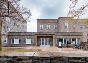A stone building with multiple windows and a central entrance. There are bicycles parked outside. - Dalhousie University Accommodations (Halifax)