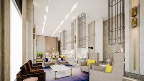 A modern living room with a blue carpet, a piano, and a sofa with yellow cushions. - Summit Galleria Cebu (Cebu City)