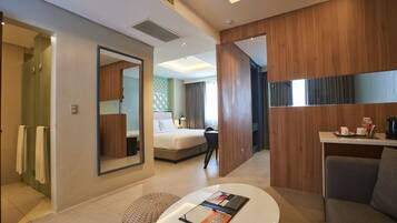 Una habitación de hotel moderna con cama, escritorio, silla y baño.