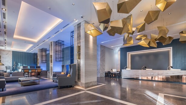 A modern lobby with a reception desk, seating area, and a staircase. - Summit Galleria Cebu (Cebu City)
