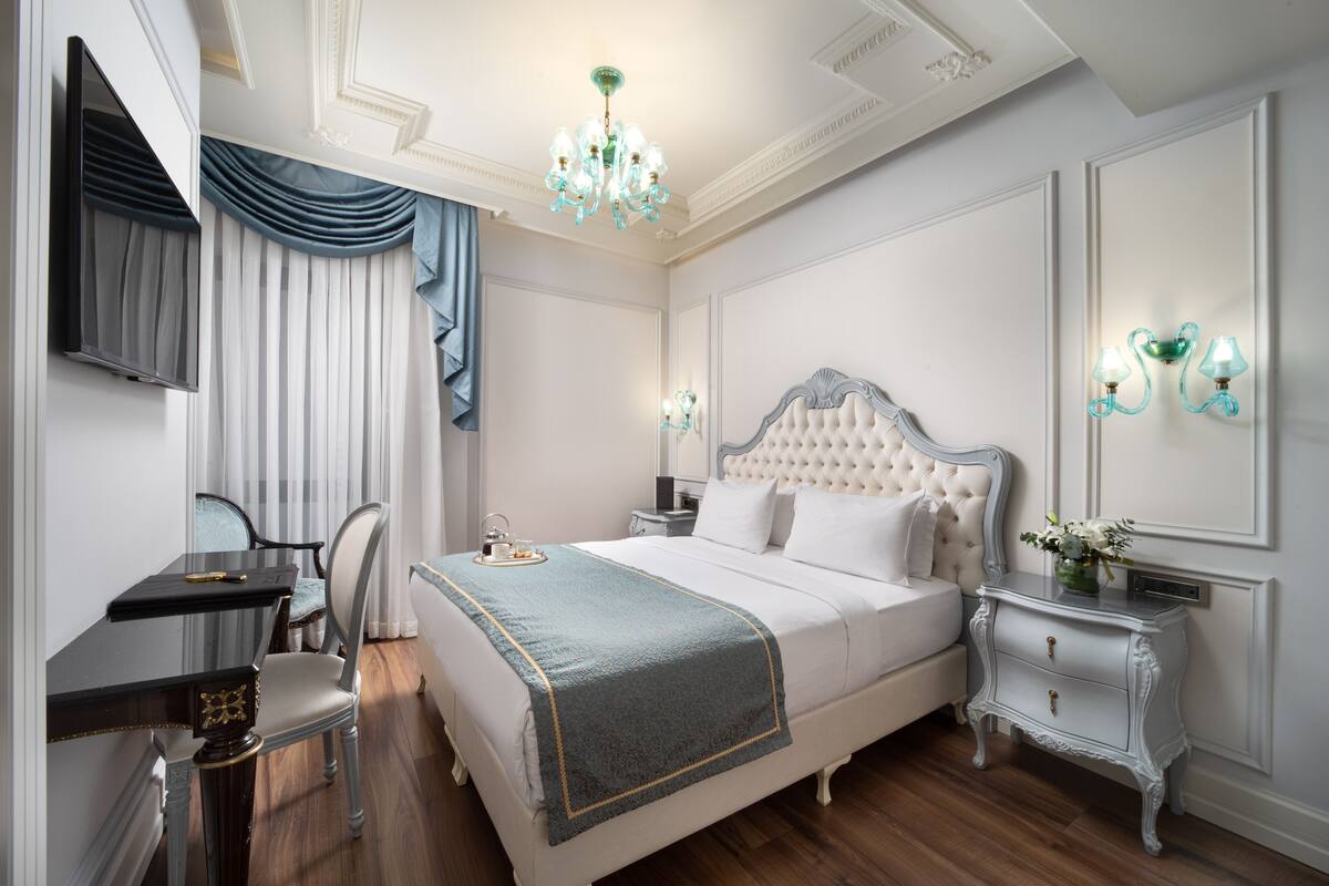 A bedroom with a bed, bedside tables, a desk, and a chair.