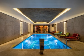 Een binnenzwembad en ligstoelen