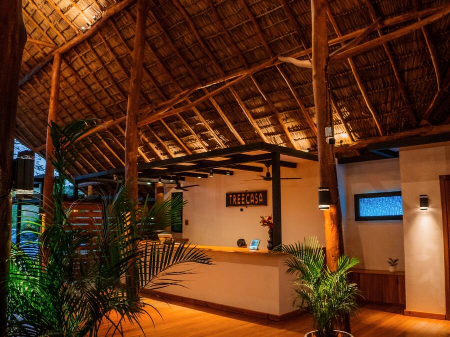 A spacious lobby with a high wooden ceiling and a reception desk.