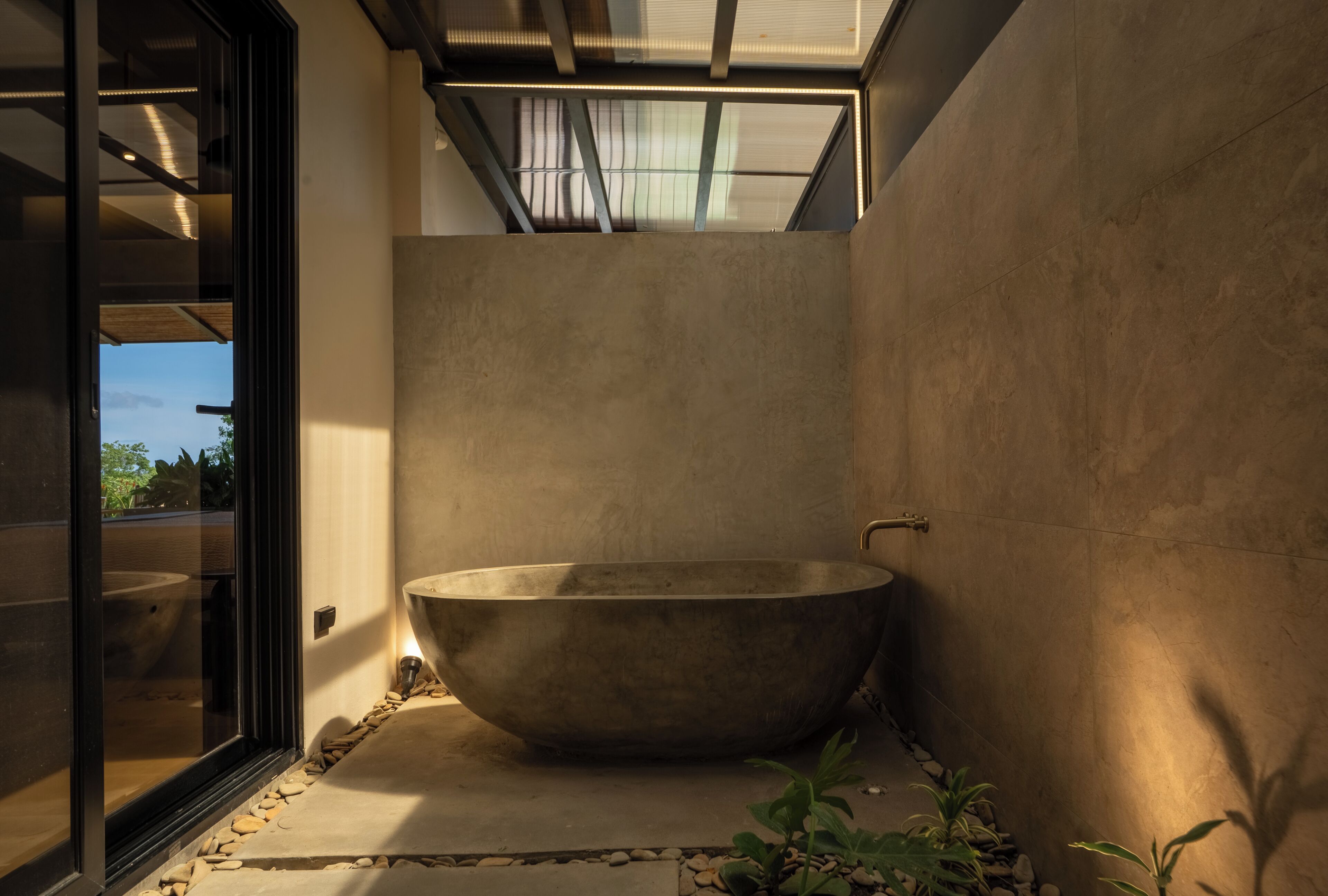 Un baño moderno con una bañera independiente grande, un tragaluz y vistas al exterior.