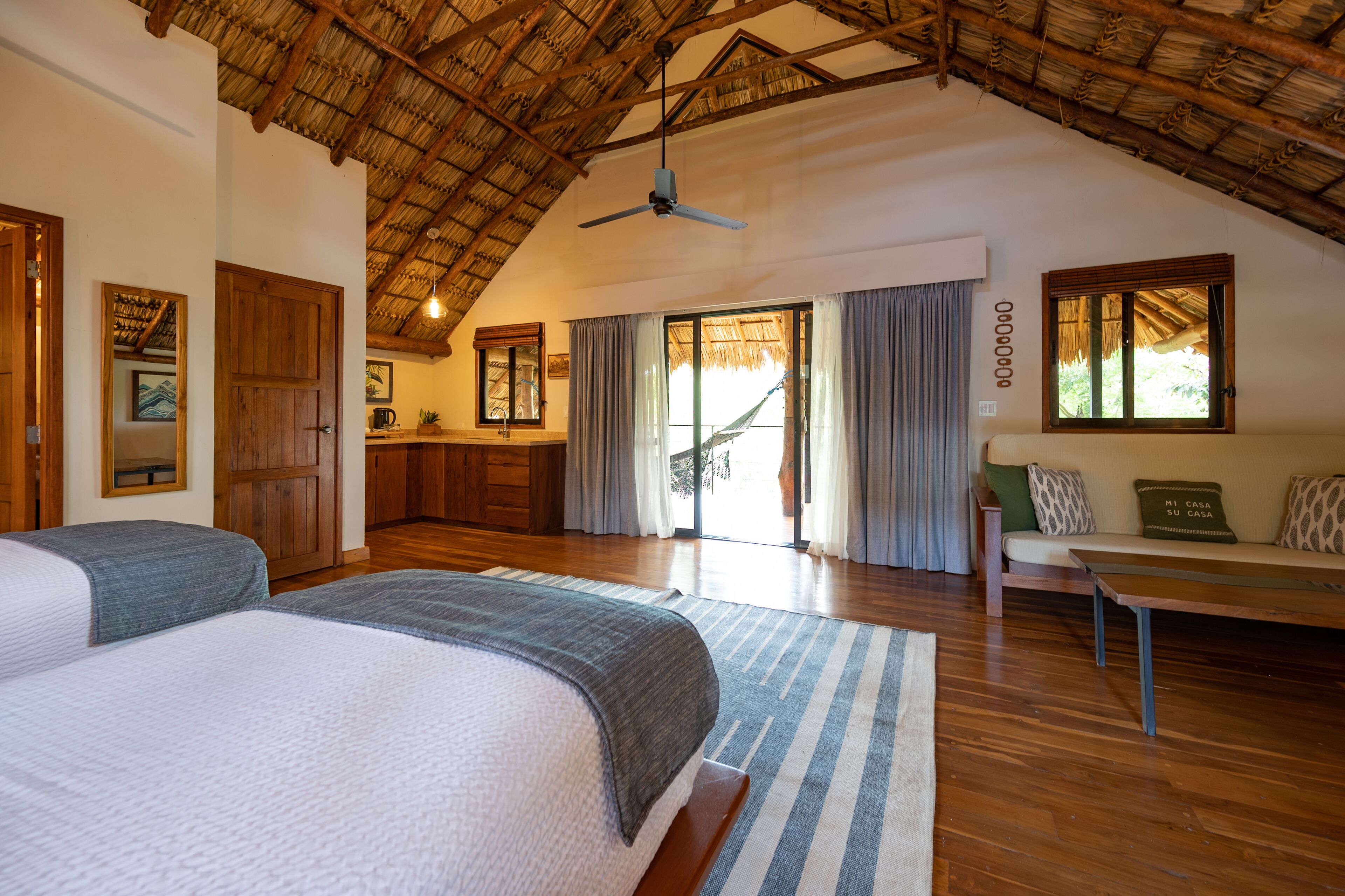 A bedroom with two beds, a dining area, and a kitchen.