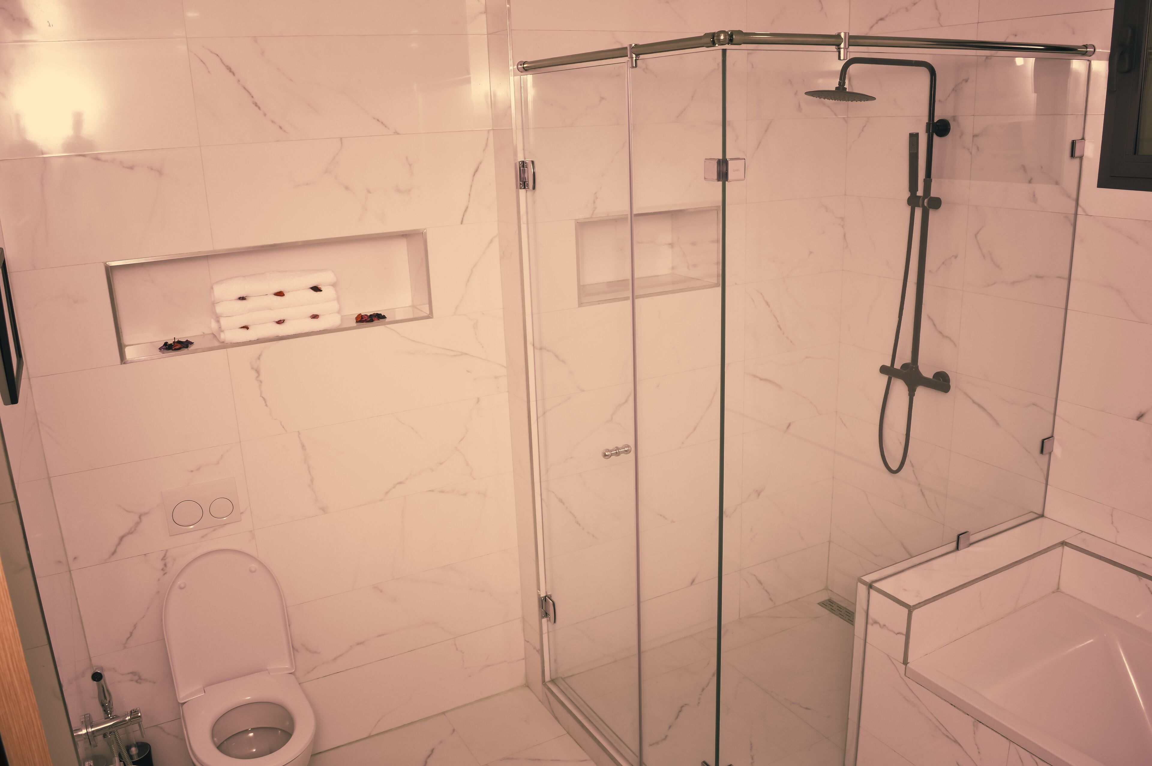 Ein modernes Badezimmer mit einer Duschkabine, einer Toilette und einem Waschtisch mit Spiegel.