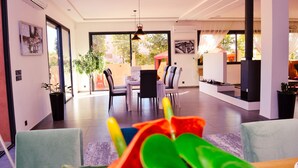 Una sala de estar moderna con comedor, ventanas amplias y chimenea.