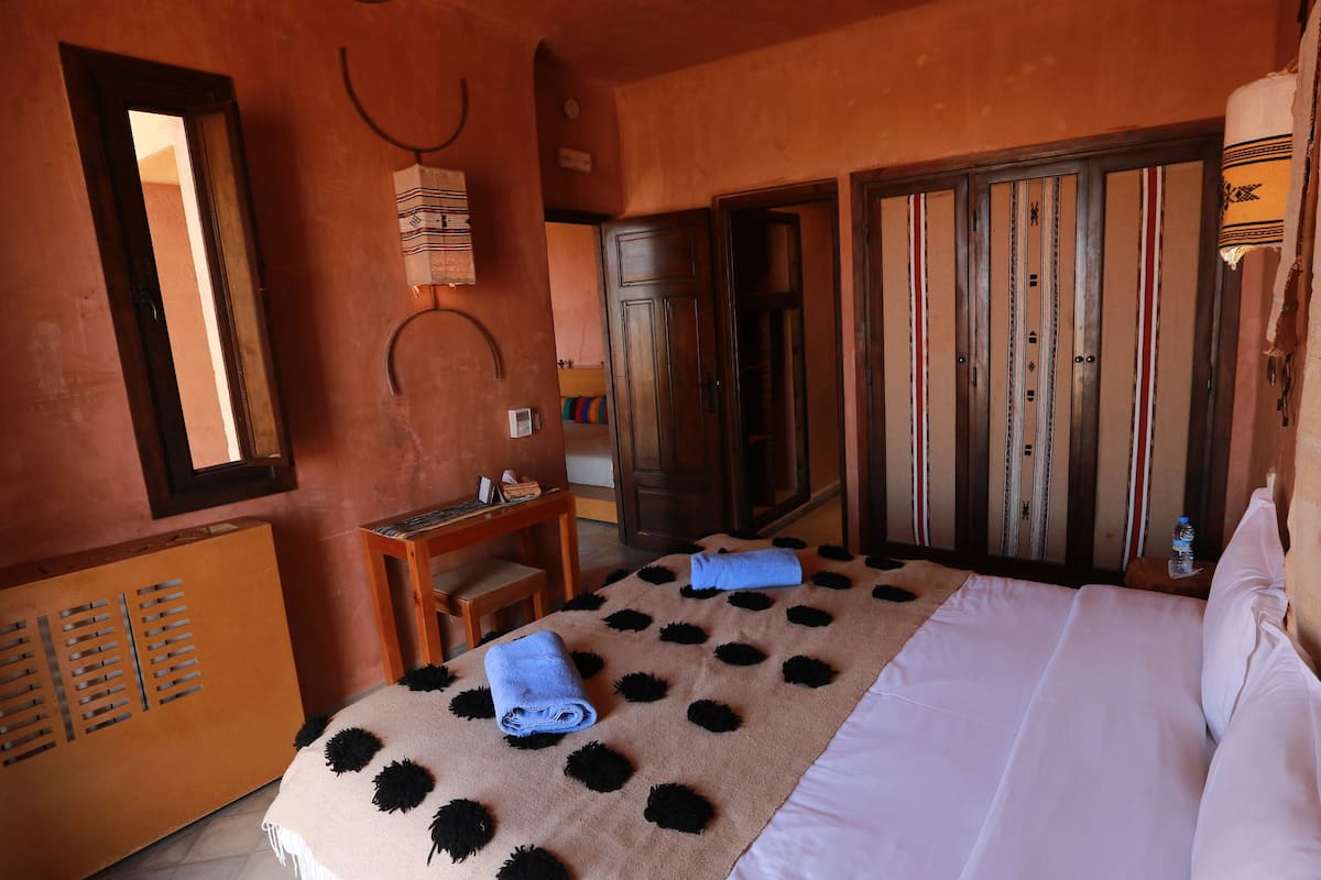 A room with a bed, a desk, and a wardrobe.