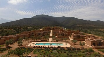 Ein Resort mit mehreren Gebäuden, einem Schwimmbecken und einer Bergkulisse.