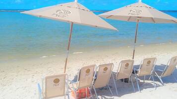 On the beach, white sand, sun loungers, beach umbrellas