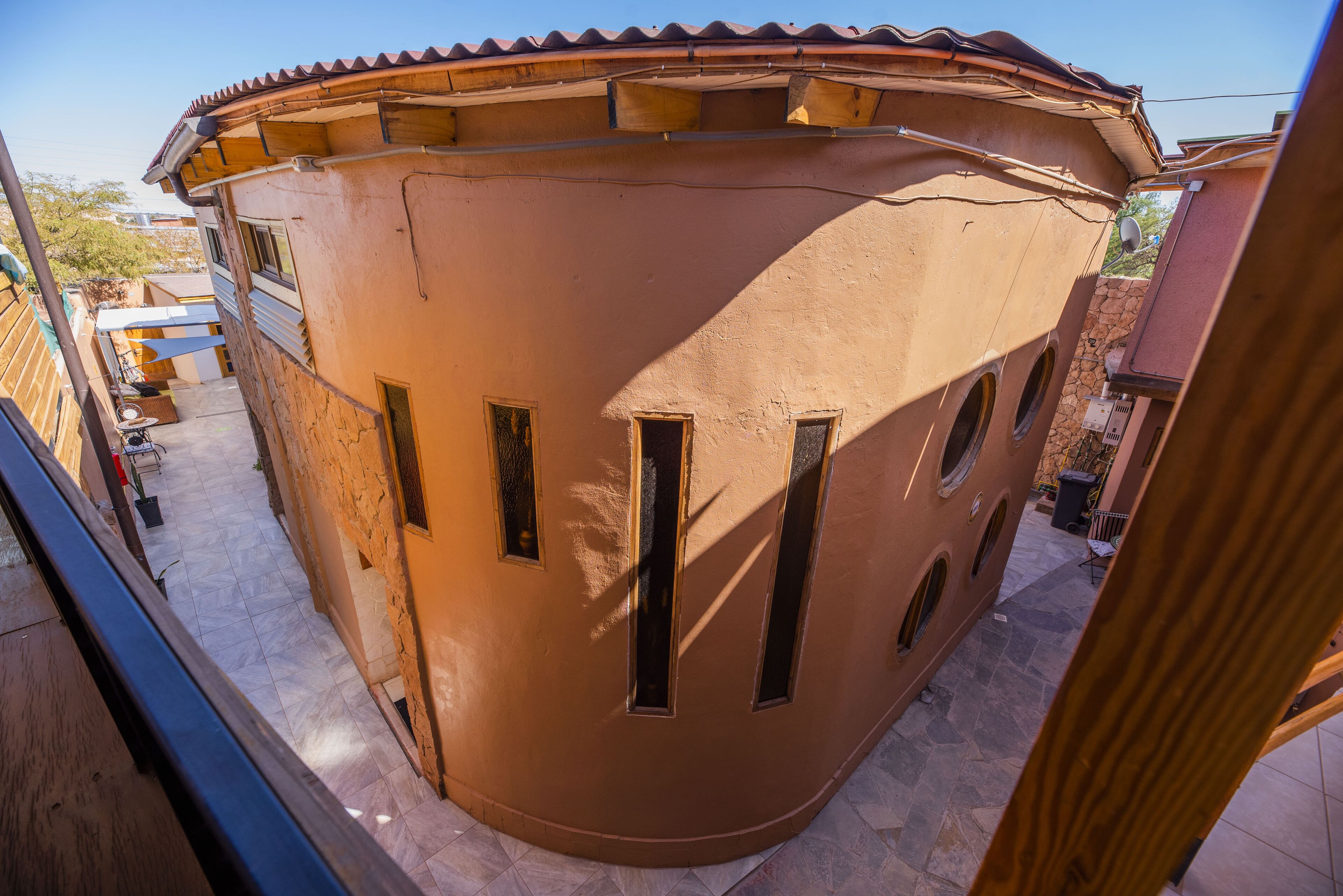 Um edifício curvo com várias janelas e telhado em telhas.