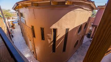Um edifício curvo com várias janelas e telhado em telhas.