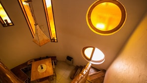 Un escalier avec des rampes en bois et une fenêtre ronde en haut.