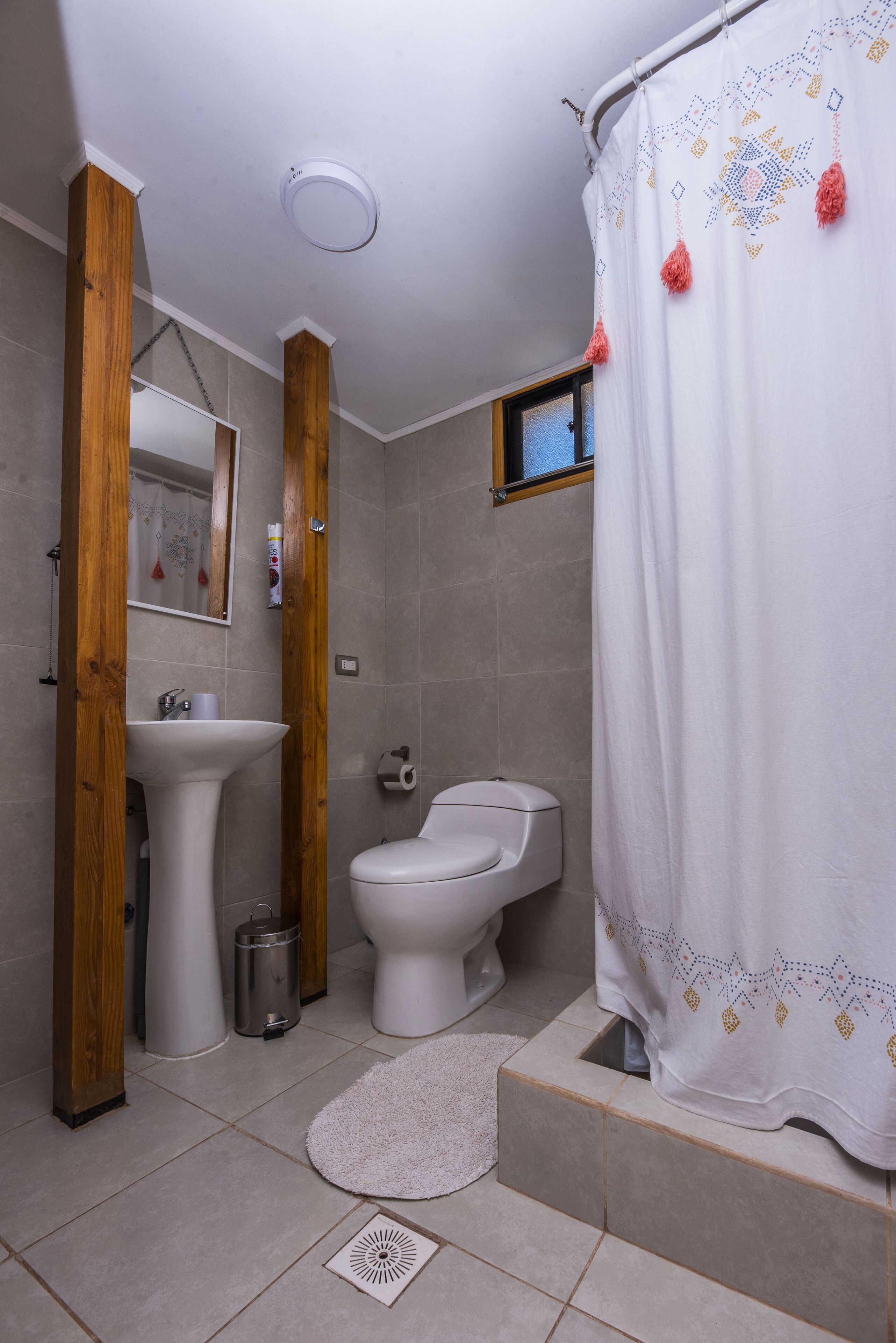 A bathroom with a white sink, toilet, and shower curtain.