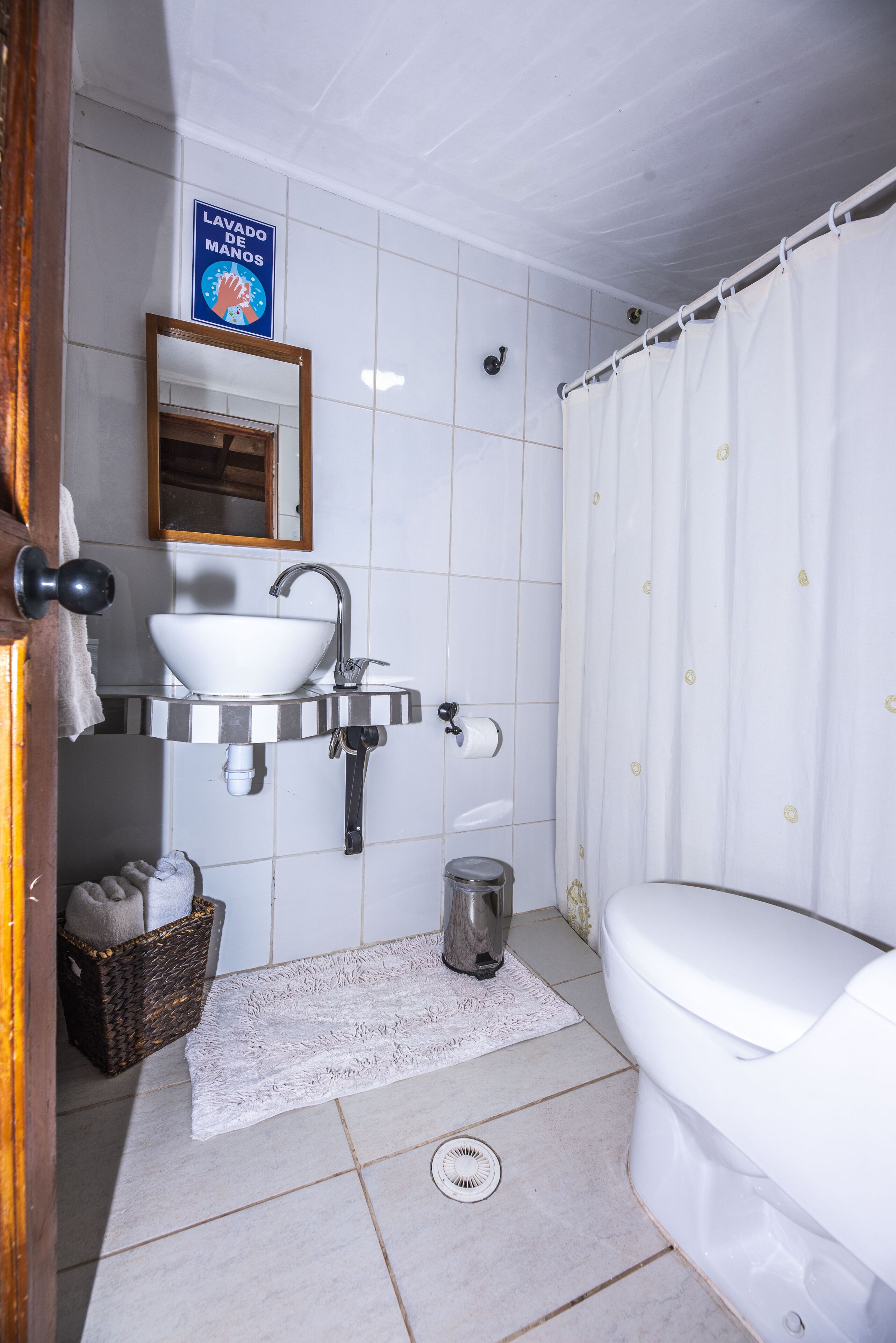 A bathroom with a white sink, a toilet, and a shower curtain.
