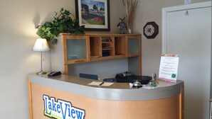 A reception desk with a 'Lake View' sign, a lamp, a framed picture, a clock, and a notice board.