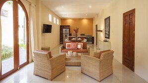 A spacious living area with a sofa set, a dining table, and a kitchen in the background. - Plaza Marbella Granada Condiminiums (Granada)