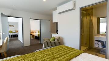 A hotel room with a bed, a chair, a desk, and a bathroom.