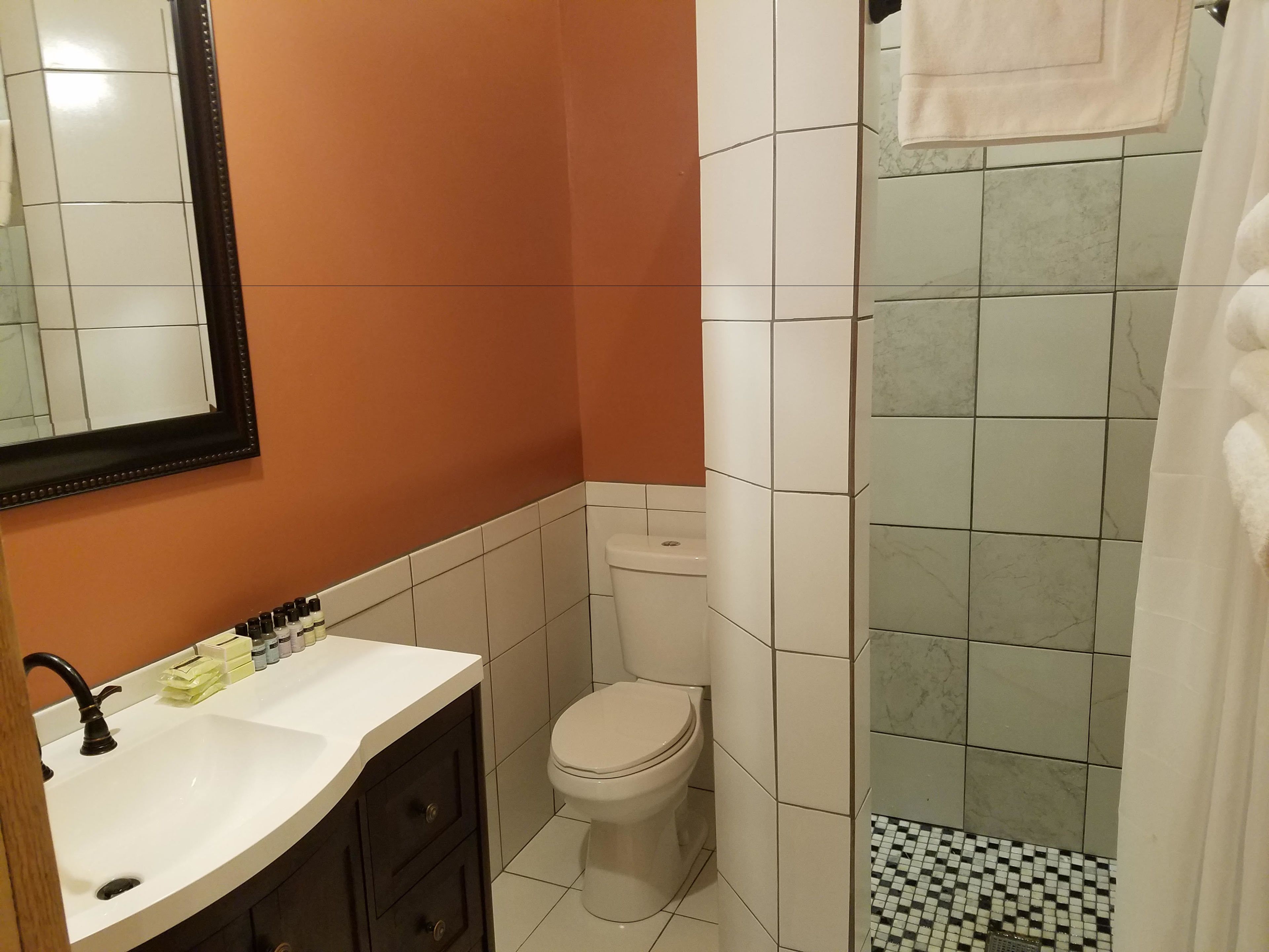 Un bagno con lavandino bianco, un water e zona doccia.