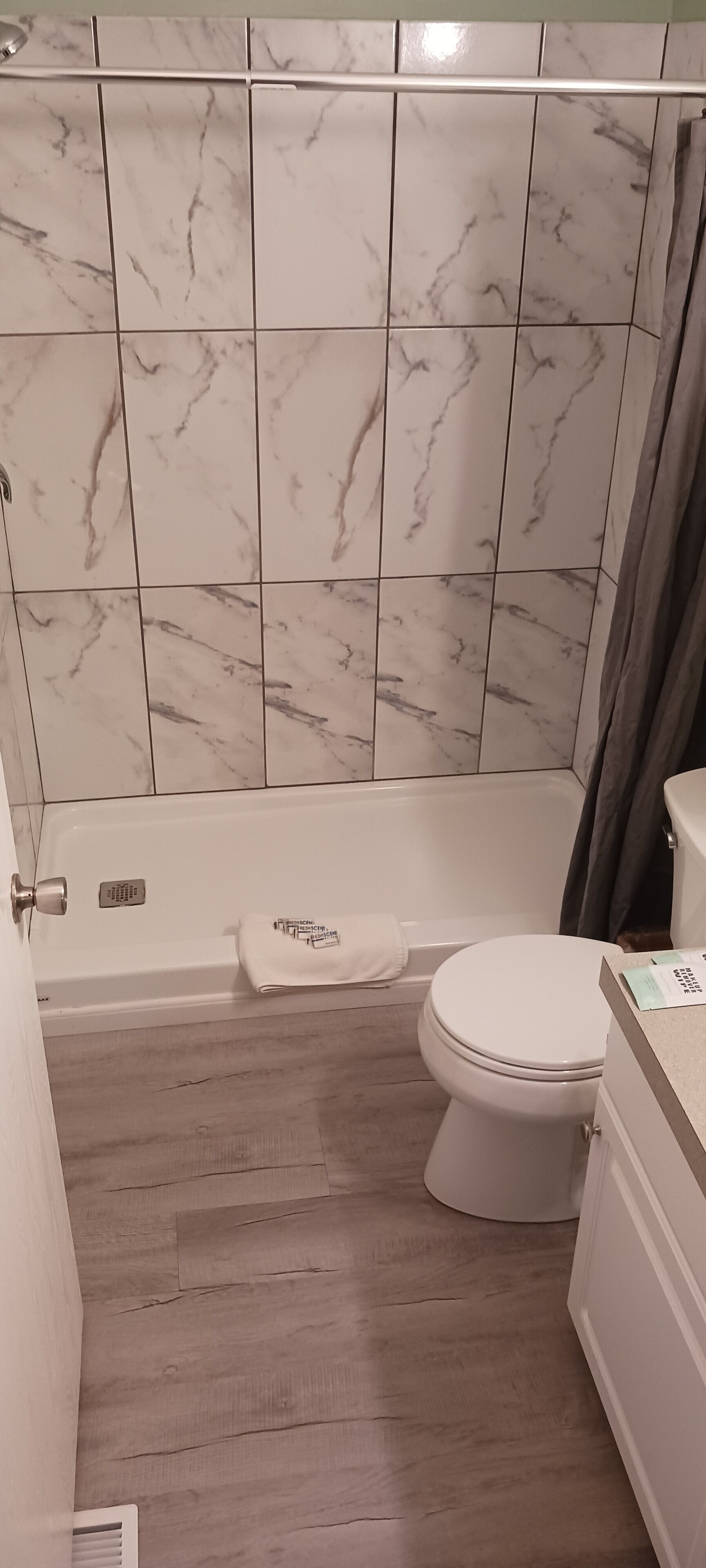 Een badkamer met een bad, toilet en douche.