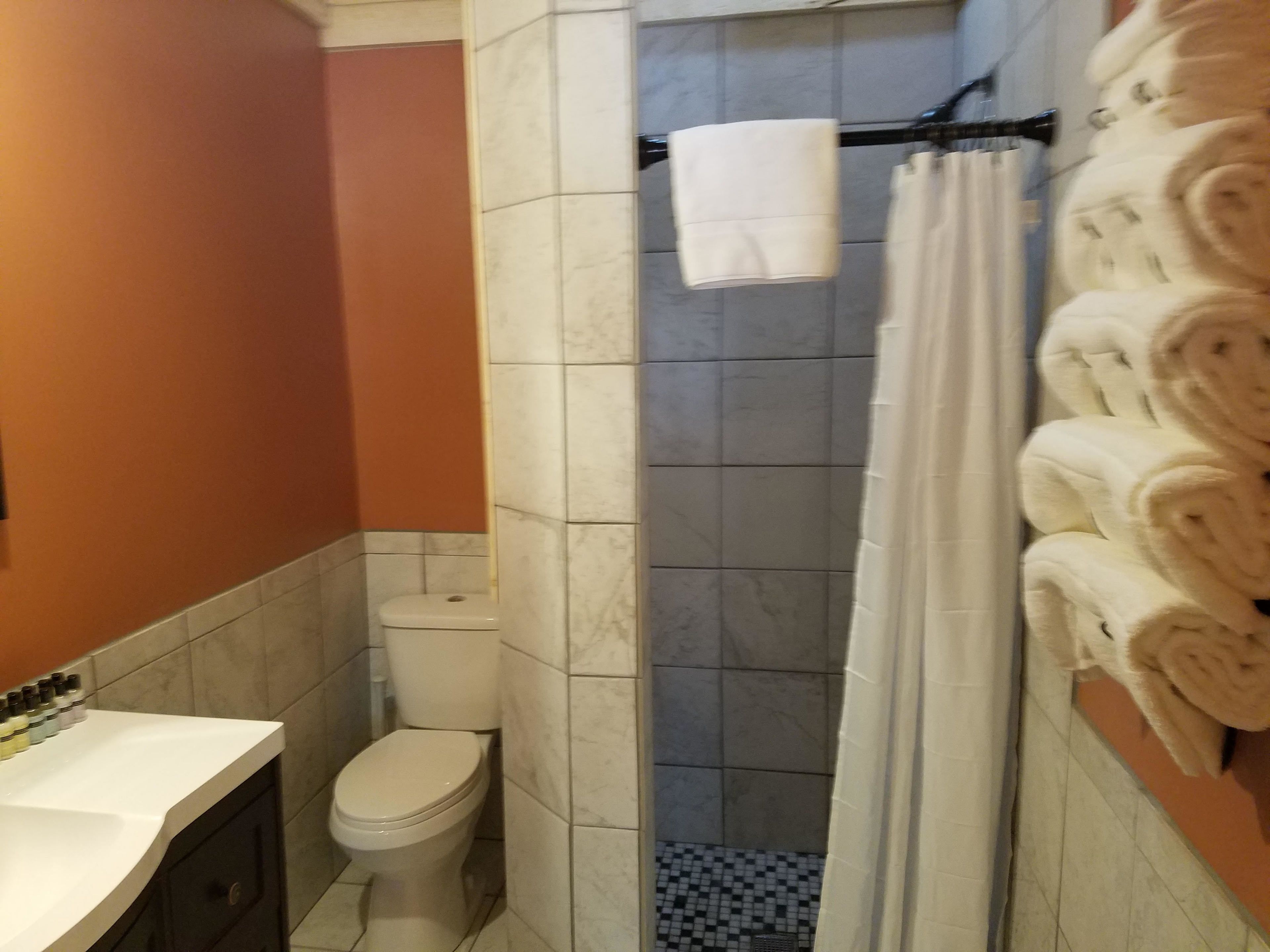 Une salle de bain comprenant des toilettes, un espace douche et un lavabo.