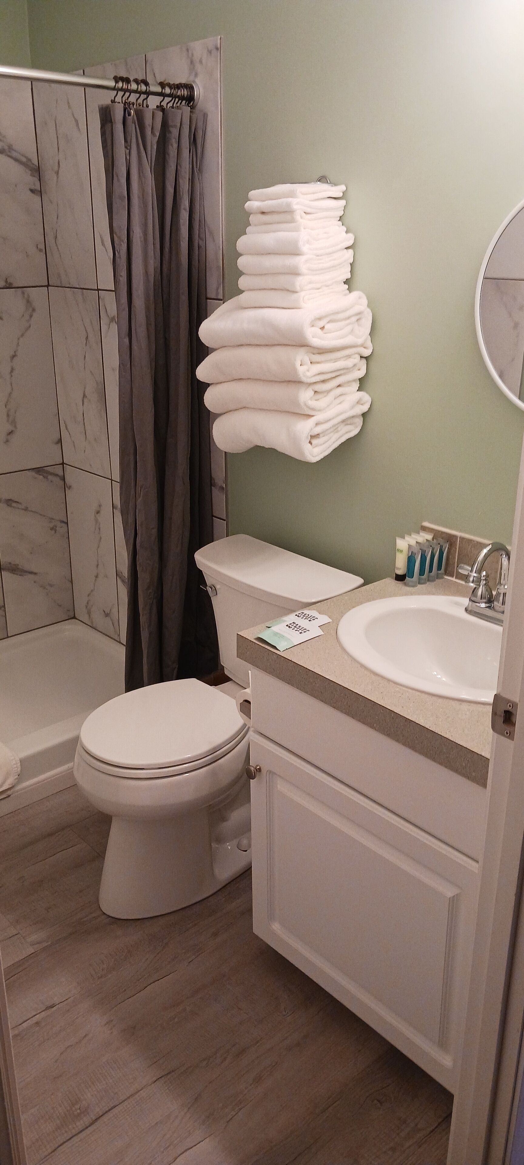 A bathroom with a toilet, sink, and shower area.