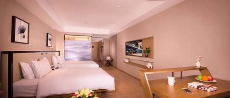 A hotel room with two beds, a desk with a chair, a small table with a vase of flowers, and a wall-mounted TV.