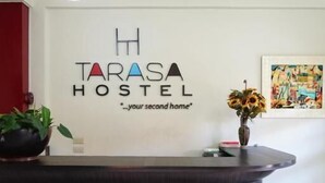 A reception desk with a sign that reads "Tarasa Hostel" and a slogan "your second home". - Tarasa Hostel (Pasay)