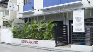 A hostel with a 'NO PARKING' sign, a signboard advertising rates for backpackers, transients, and tourists, and a contact number. - Tarasa Hostel (Pasay)
