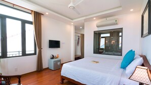 A hotel room with a bed, a TV, a window, a table with teapots, and an air conditioning unit. - An Bang Beach Dolphin Homestay Hoi An (Da Nang)