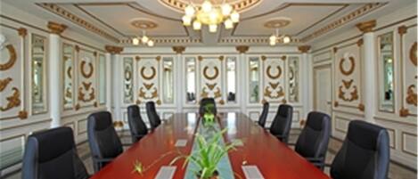 A conference room with a long table, chairs, and a chandelier.
