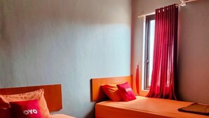 A hotel room with two beds, each with matching headboards and pillows, and a window with red curtains. - Budi House & Food Station (Cimahi)