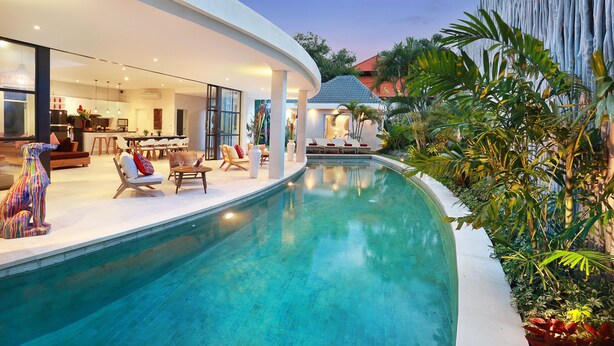 Uma casa moderna com piscina, área de estar externa e um jardim bem cuidado.
