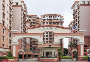 Un immeuble à plusieurs étages doté de balcons et d’une enseigne indiquant : « Marina Court Resort Condominium ».