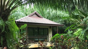 A small house with a tiled roof, surrounded by dense tropical vegetation. - Khao Sok Palm Garden Resort (Phanom)