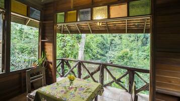 A wooden cabin with a balcony overlooking a forest.