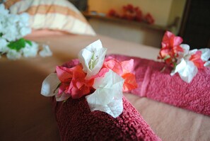 A bed with a red blanket and white flowers on it. - La Case du Pecheur (Bambous Virieux)