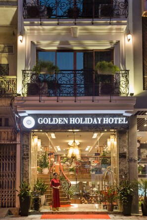 Enter a classic hotel with a grand staircase and decorative iron railings.