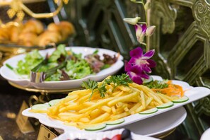 Savor a meal amidst elegant chairs and a beautiful flower arrangement.