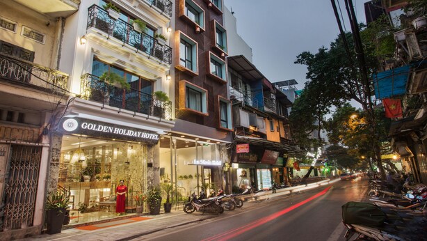 A hotel with a modern facade, a visible entrance, and a sign indicating it is a holiday hotel. - Hanoi Golden Holiday Hotel (Hanoi)