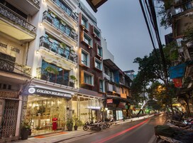Un hotel con fachada moderna, entrada visible y un letrero que indica que es un hotel vacacional.