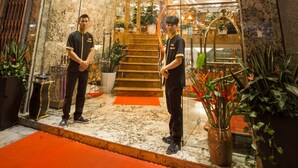 The exterior of the Golden Holiday Hotel with a marble facade, a red carpet entrance, and two staff members standing at the entrance. - Hanoi Golden Holiday Hotel (Hanoi)