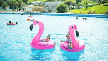A swimming pool with inflatable flamingo floats.