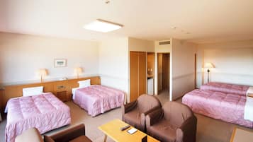 Quarto de hotel com duas camas, uma escrivaninha, uma cadeira, mesa de cabeceira e abajur.