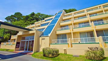 A multi-story hotel with a flat roof, balconies, and a covered entrance.