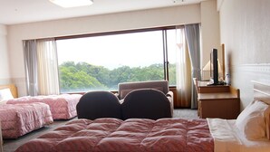 A hotel room with a large bed, two smaller beds, a desk with a chair, a TV, and a view of the outdoors. - Tsumagoi Resort Sai No Sato (Kakegawa)