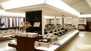 A buffet area with multiple serving stations, a central floral arrangement, and a variety of food items displayed in glass containers. - Tsumagoi Resort Sai No Sato (Kakegawa)