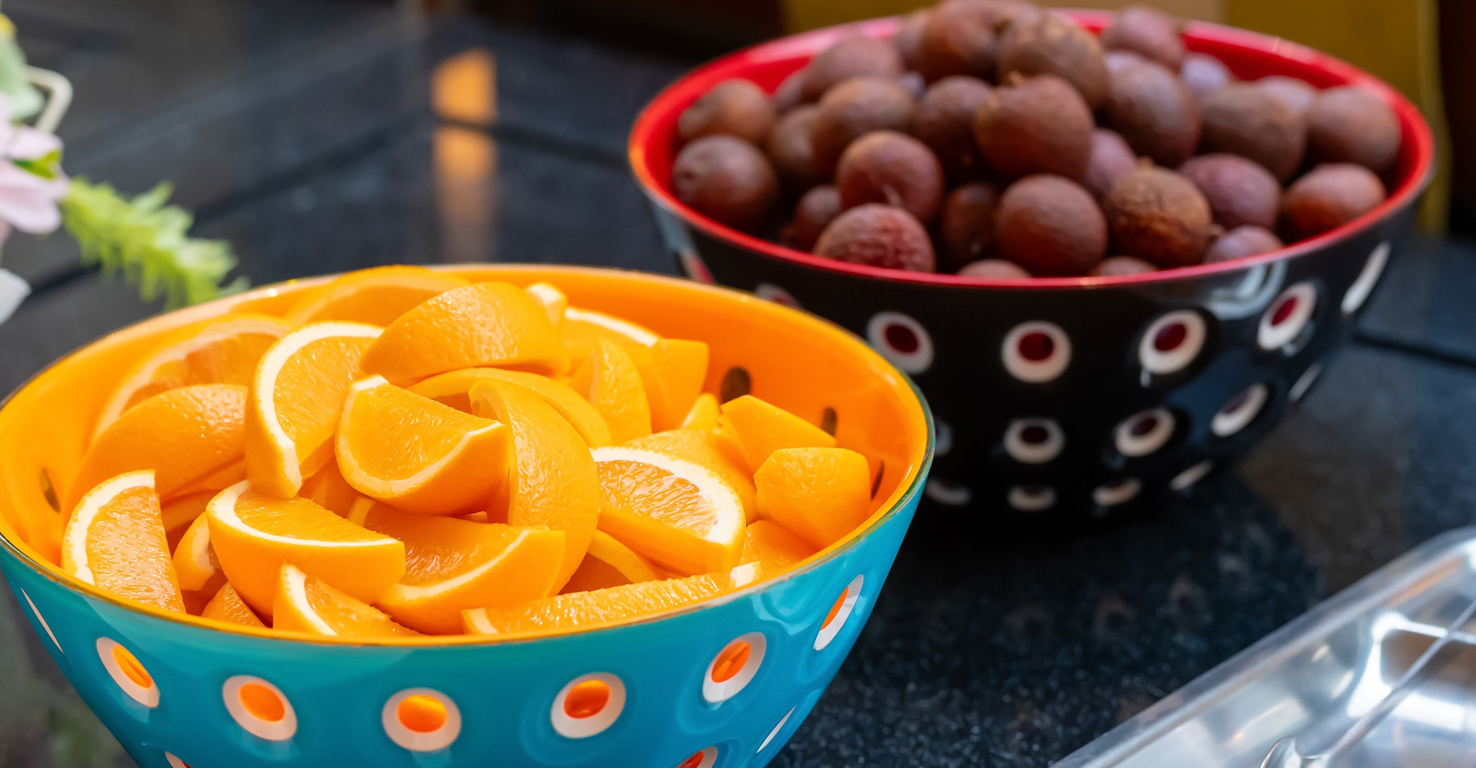 Two bowls of fruit on a countertop.